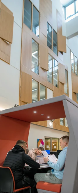 Students working together in a study pod at Springburn Campus, with tall windows and modern wood-panelled interiors in the background. Students working together in a study pod at Springburn Campus, with tall windows and modern wood-panelled interiors in the background.